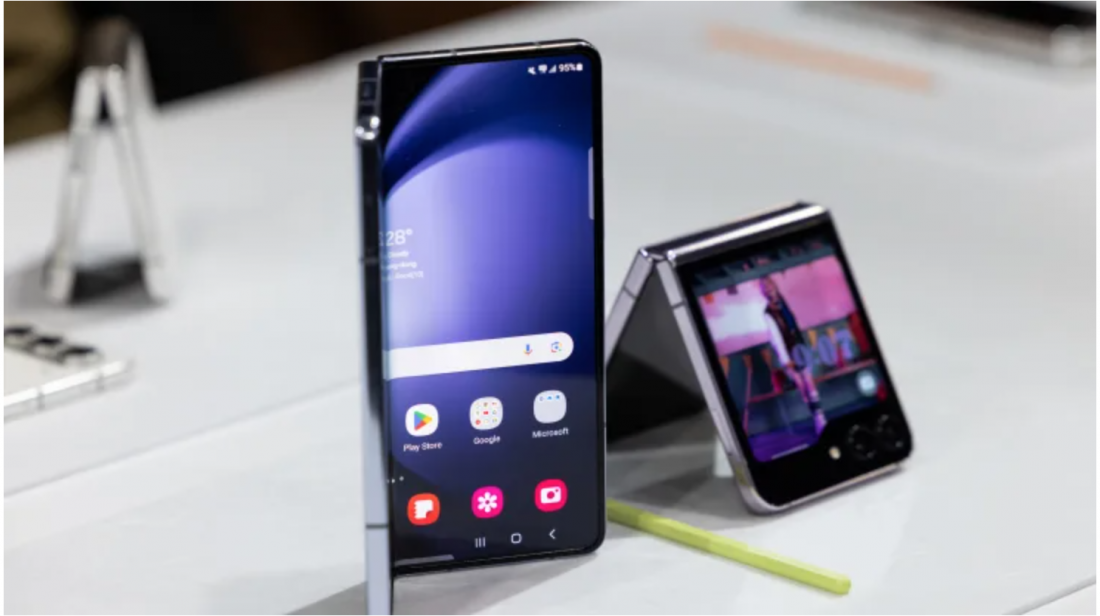 Một chiếc điện thoại thông minh Samsung Galaxy Z Fold 5, bên trái, một chiếc điện thoại thông minh Galaxy Z Flip 5 trong sự kiện Galaxy Unpacked ở Seoul, Hàn Quốc, vào thứ Tư, ngày 26 tháng 7 năm 2023. Samsung đã giới thiệu thế hệ thứ năm của điện thoại thông minh có thể gập lại vào thứ Tư, nhằm đáp trả một thị trường trì trệ cho các thiết bị và các sản phẩm đối thủ sắp ra mắt của Apple Inc. Ảnh SeongJoonCho | Bloomberg 