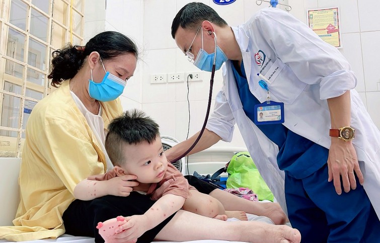 Bác sĩ Đỗ Châu Việt, Trưởng Khoa Hồi sức nhiễm Covid-19, Bệnh viện Nhi Đồng 2 (TP HCM) thăm khám cho bệnh nhi sốt xuất huyết nặng. Ảnh: Người Lao động